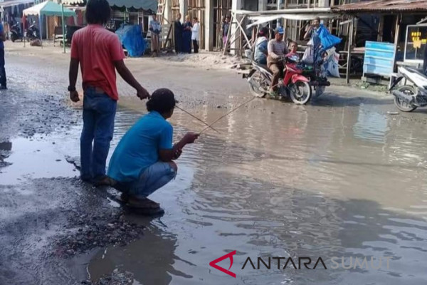 Warga mancing di jalan mirip kolam